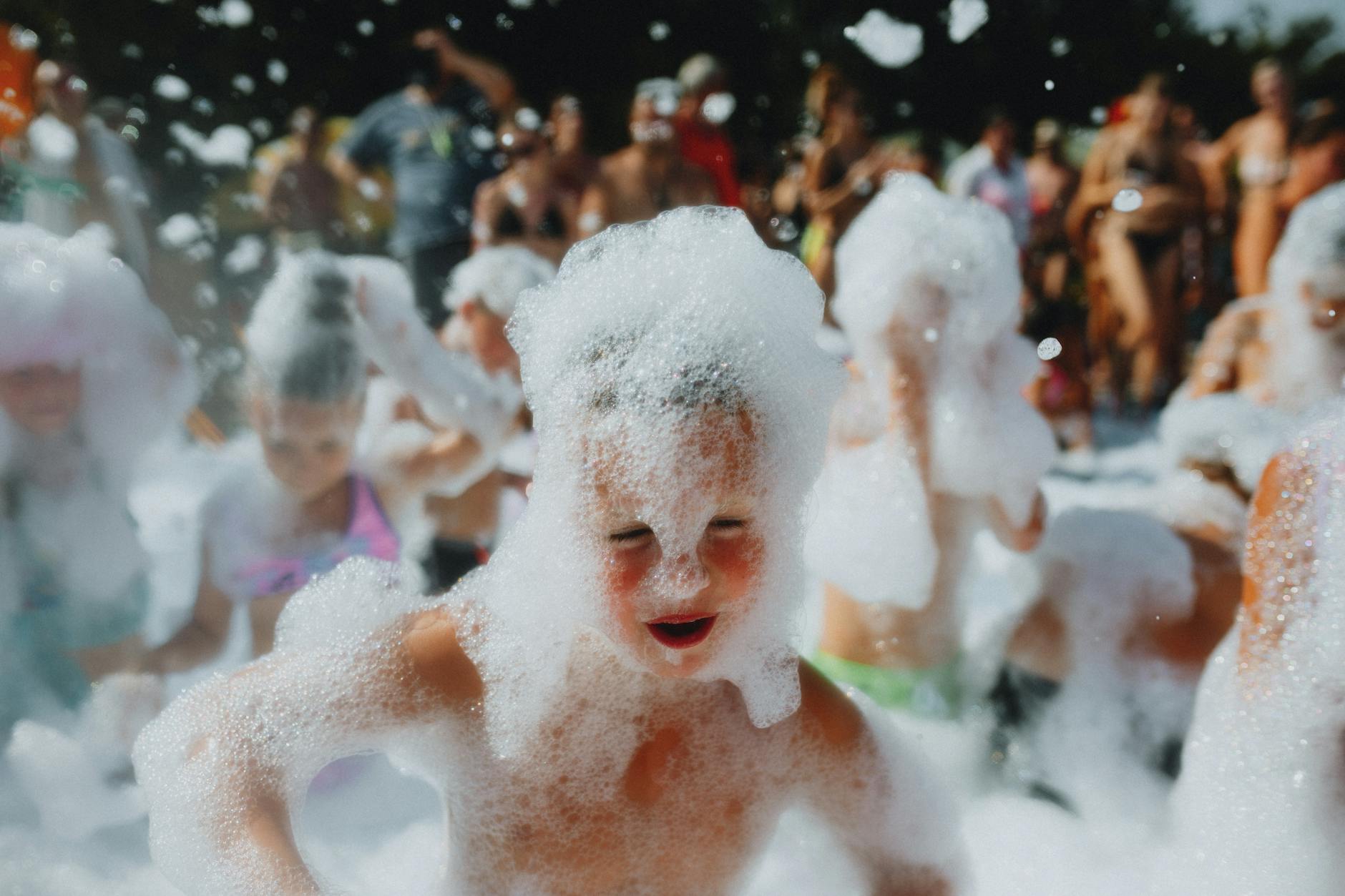 a group of children playing in a foam bath